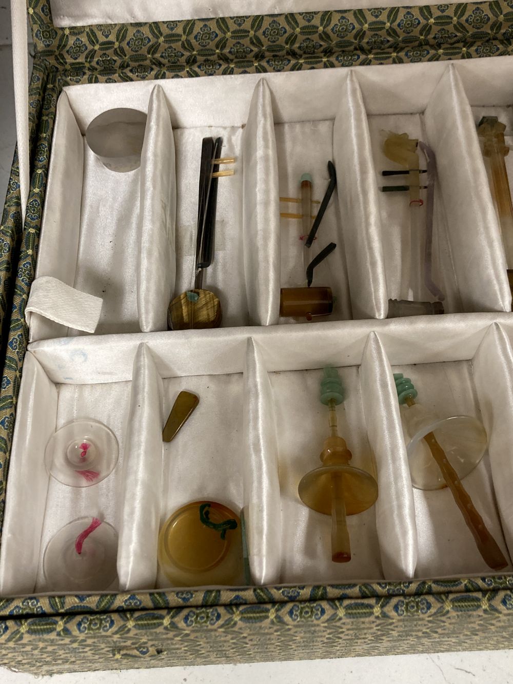 A collection of Chinese carved agate and other hardstone models of miniature musical instruments, together with hardwood stands, boxed